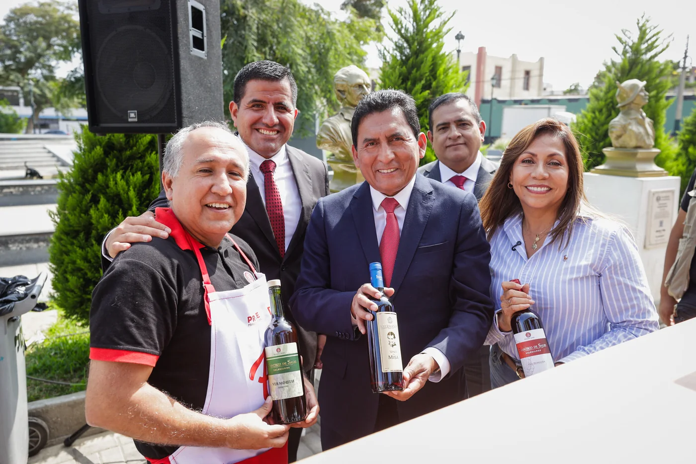Participantes de una feria con botellas de la Vinícola Salesiana